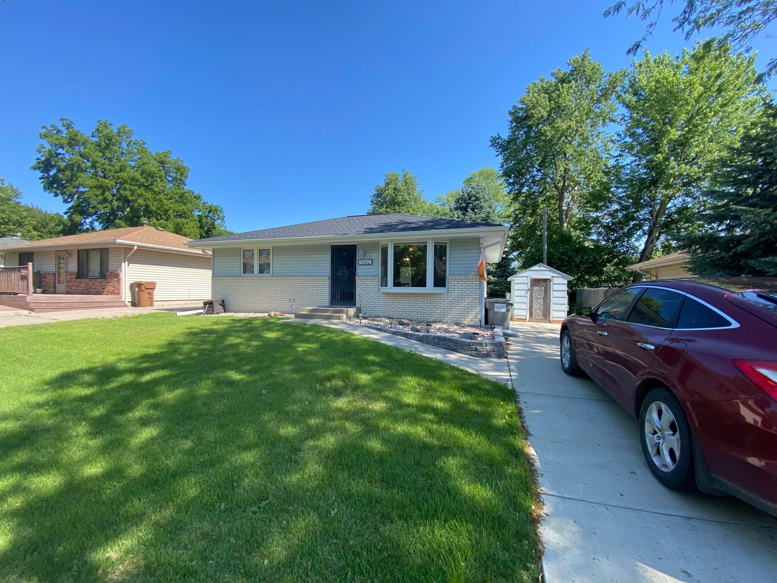 A well-kept single-storey Lincoln ranch house with a green front lawn and a driveway alongside.