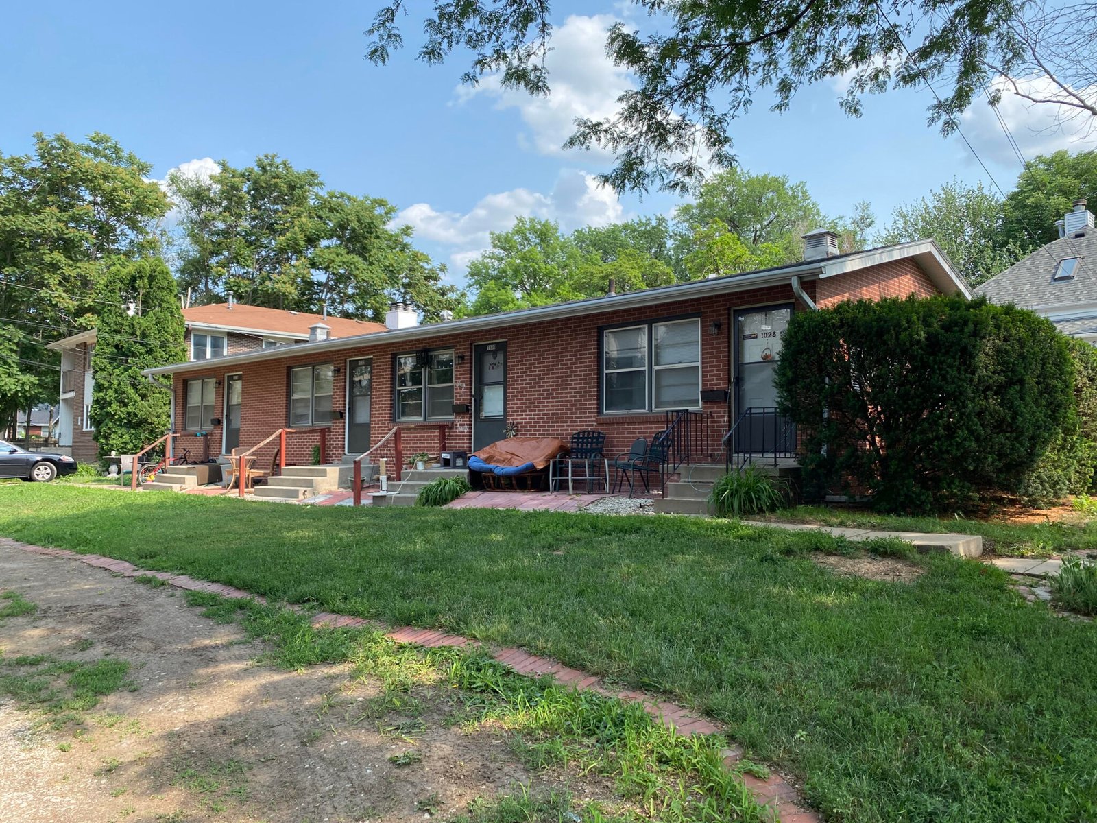 A single-storey brick multi-unit rental building in Lincoln with separate entrances and a shared lawn.